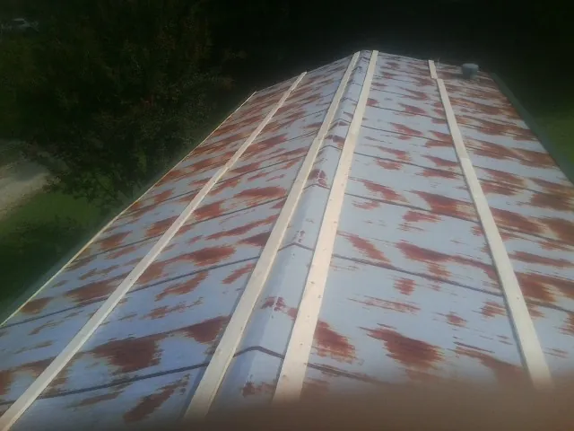 Rusted metal roof panels with new wood purlins before replacement — Storm Damage Roof Repair in Bankston by Roofing Brothers