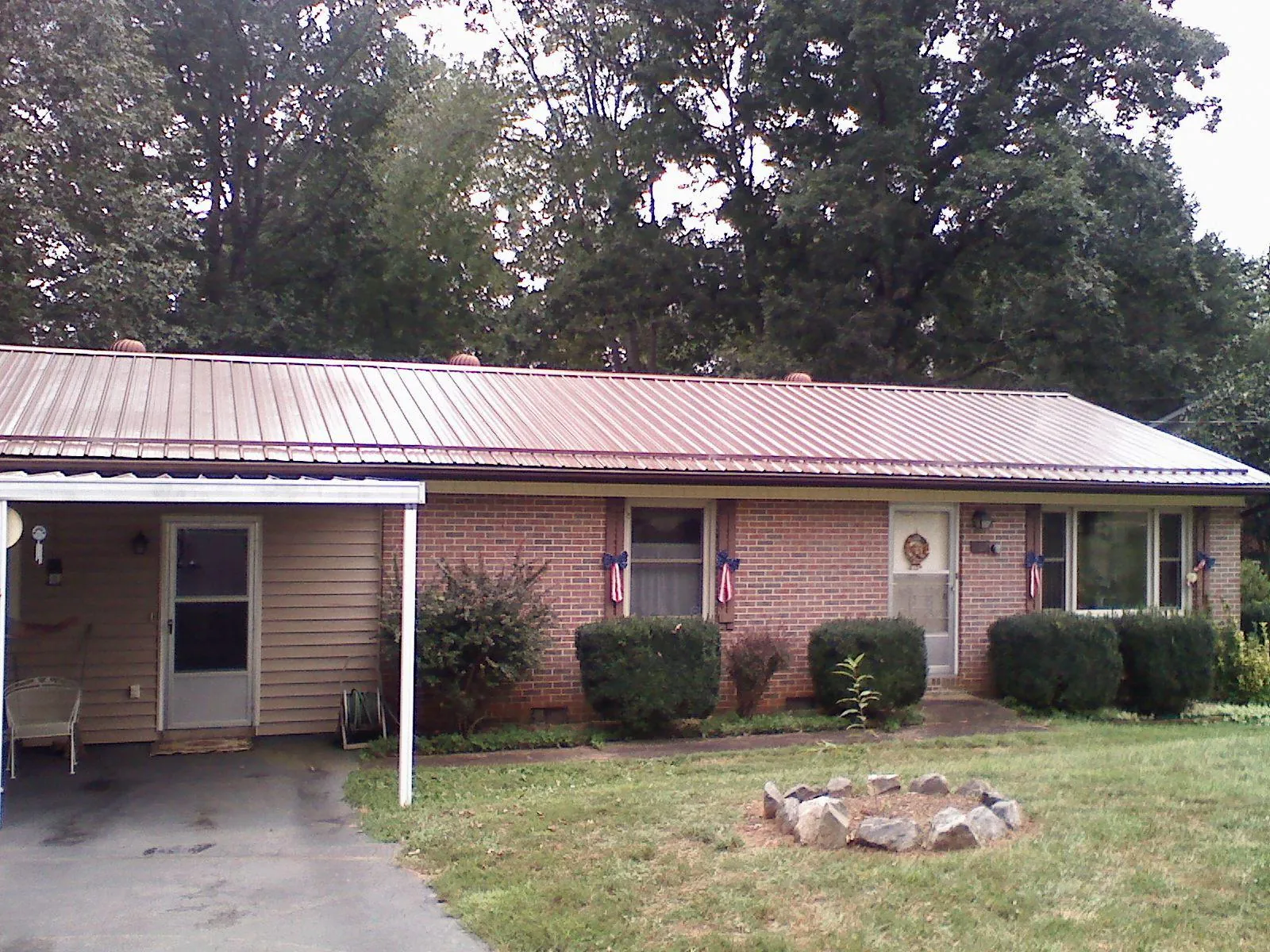 Bronze metal roof and carport on a brick ranch home — Roof Repair work by our crew in Bankston