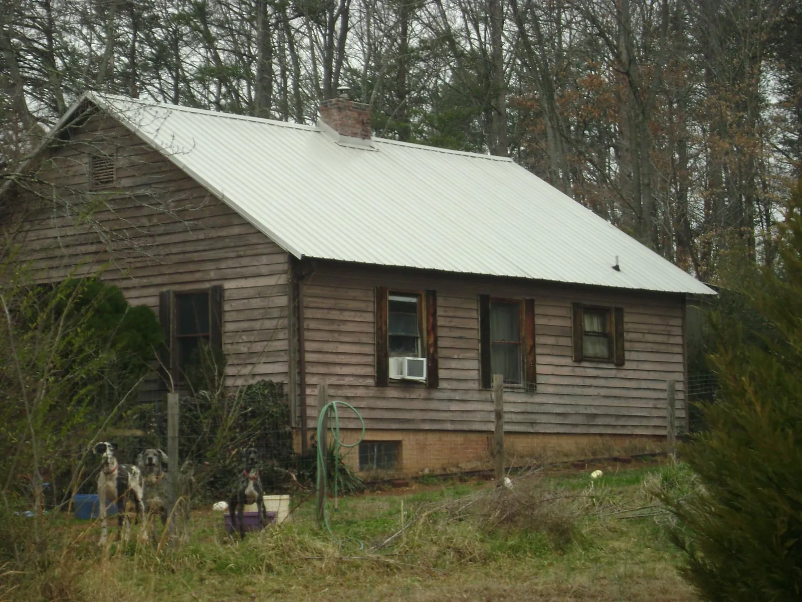 White metal roof on an old wood sided farmhouse, from a Metal Roof Installation job in Bankston